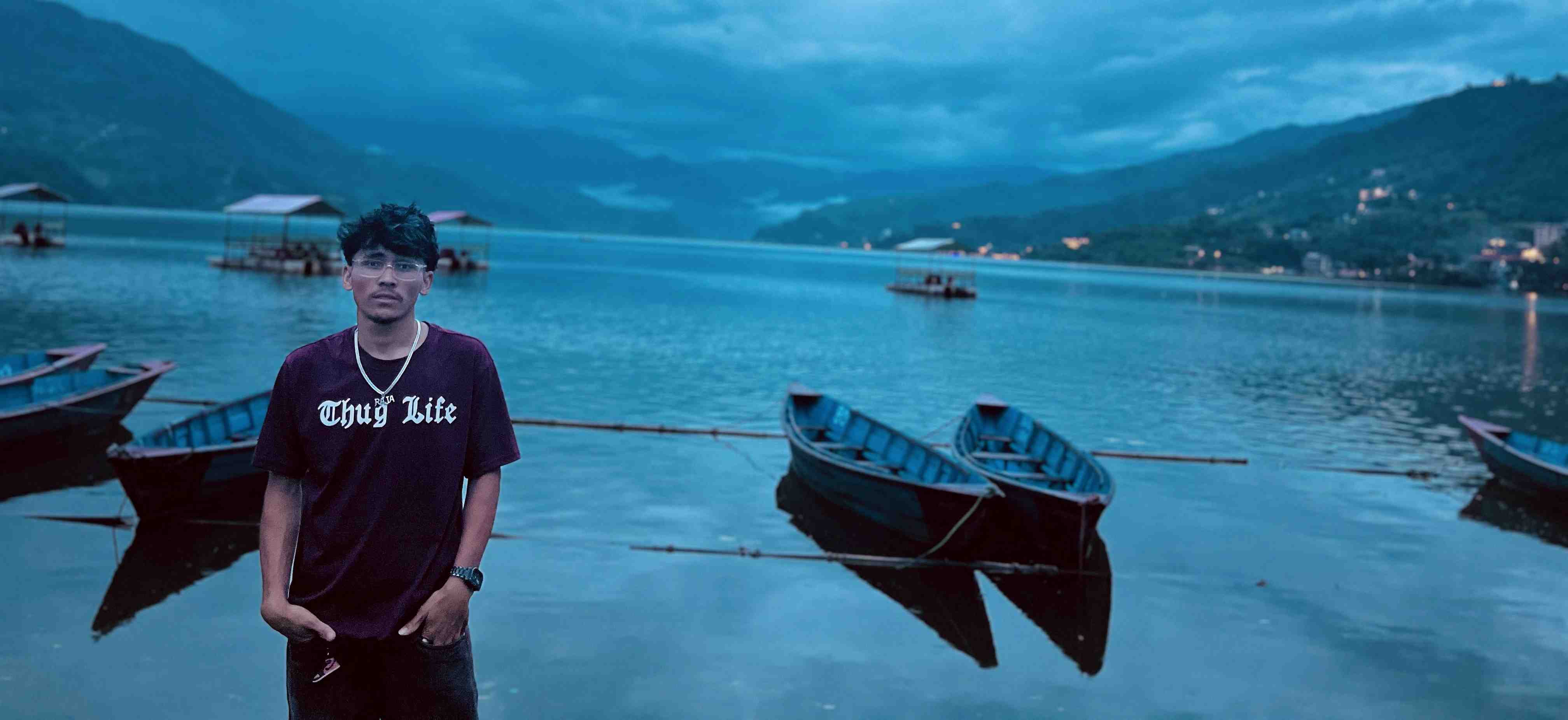 Raja Shahi standing at the edge of Fewa Lake at dusk in Pokhara